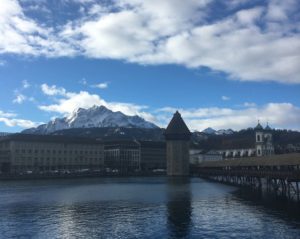 boardwalk over water with medieval town and mountain behind